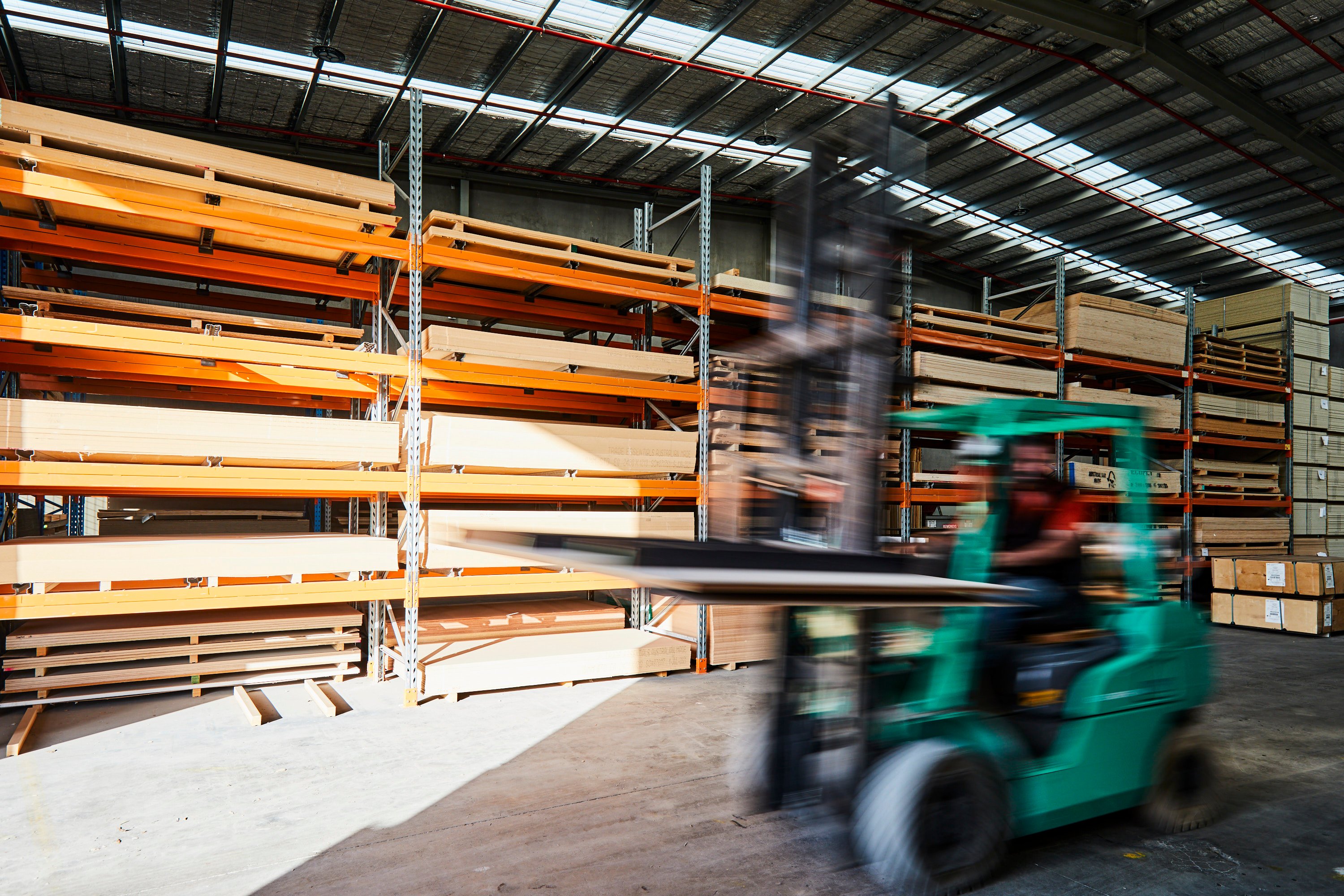 Dan Wray driving a forklift in front of Birch Plywood sheets at the factory in Plyco Mornington