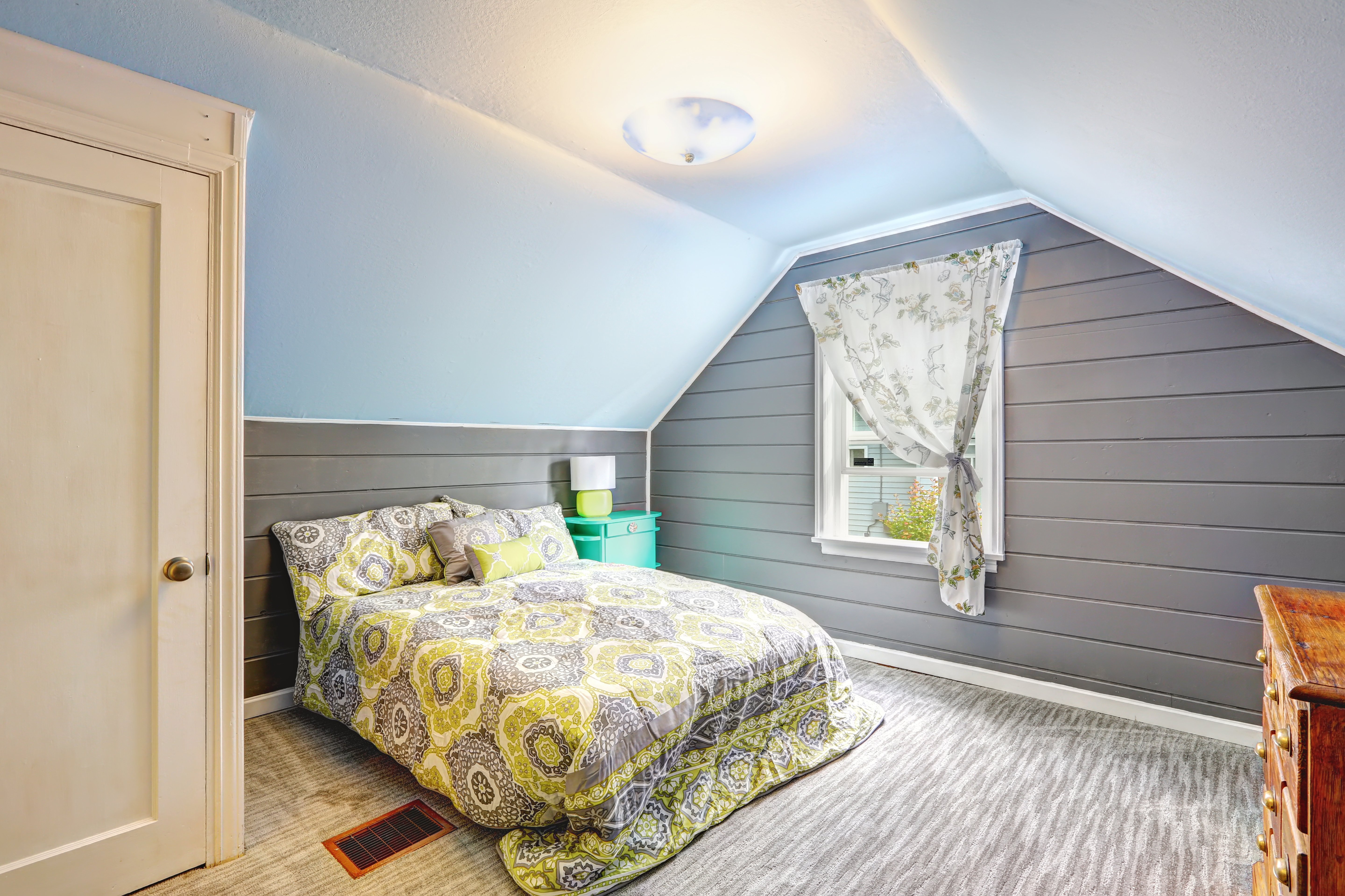 Vaulted ceiling horizontal wall cladding used in a bedroom attic